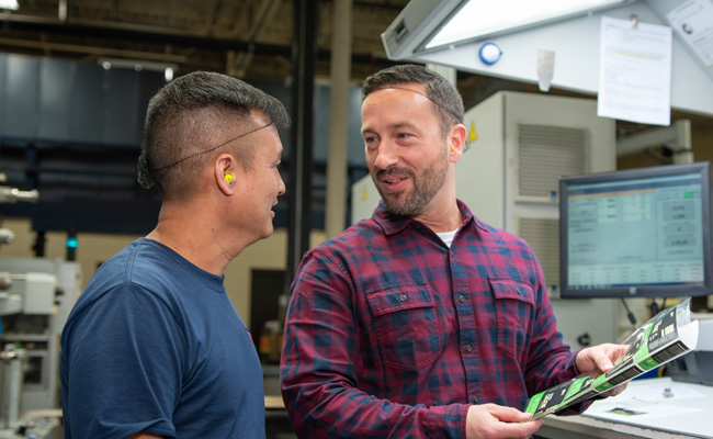 hero-contact-m Two Belmark employees talking in the production facility