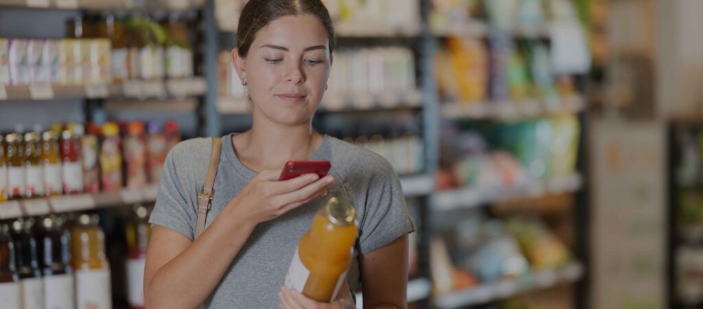 Woman scanning QR code on a product in a grocery store