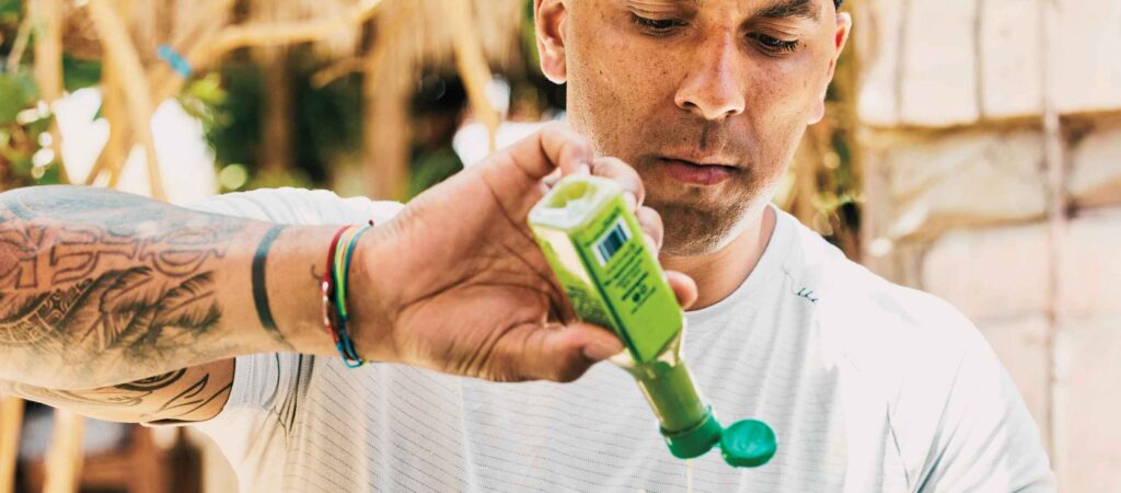Man with a bottle of hot sauce that has a pressure sensitive label on it.