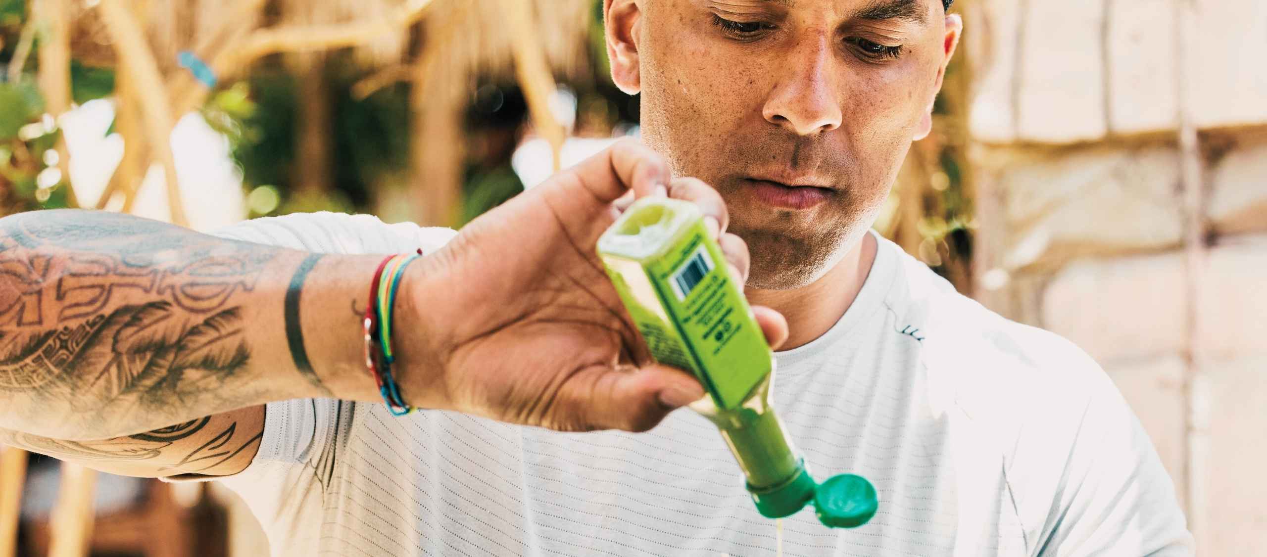 Man with a bottle of hot sauce that has a pressure sensitive label on it.