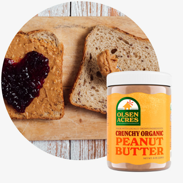 A picture of a peanut butter and jelly sandwich next to a jar of crunchy
