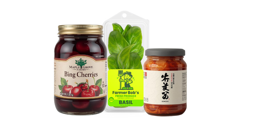 A jar of Bing cherries, a jar of kimchi and a clamshell of fresh basil with a label on it.